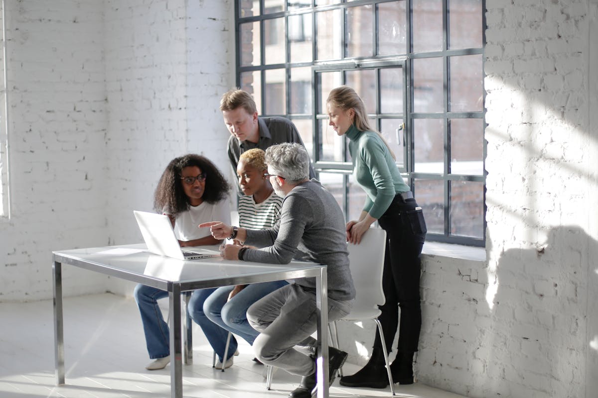 A team working together around a laptop in a bright office